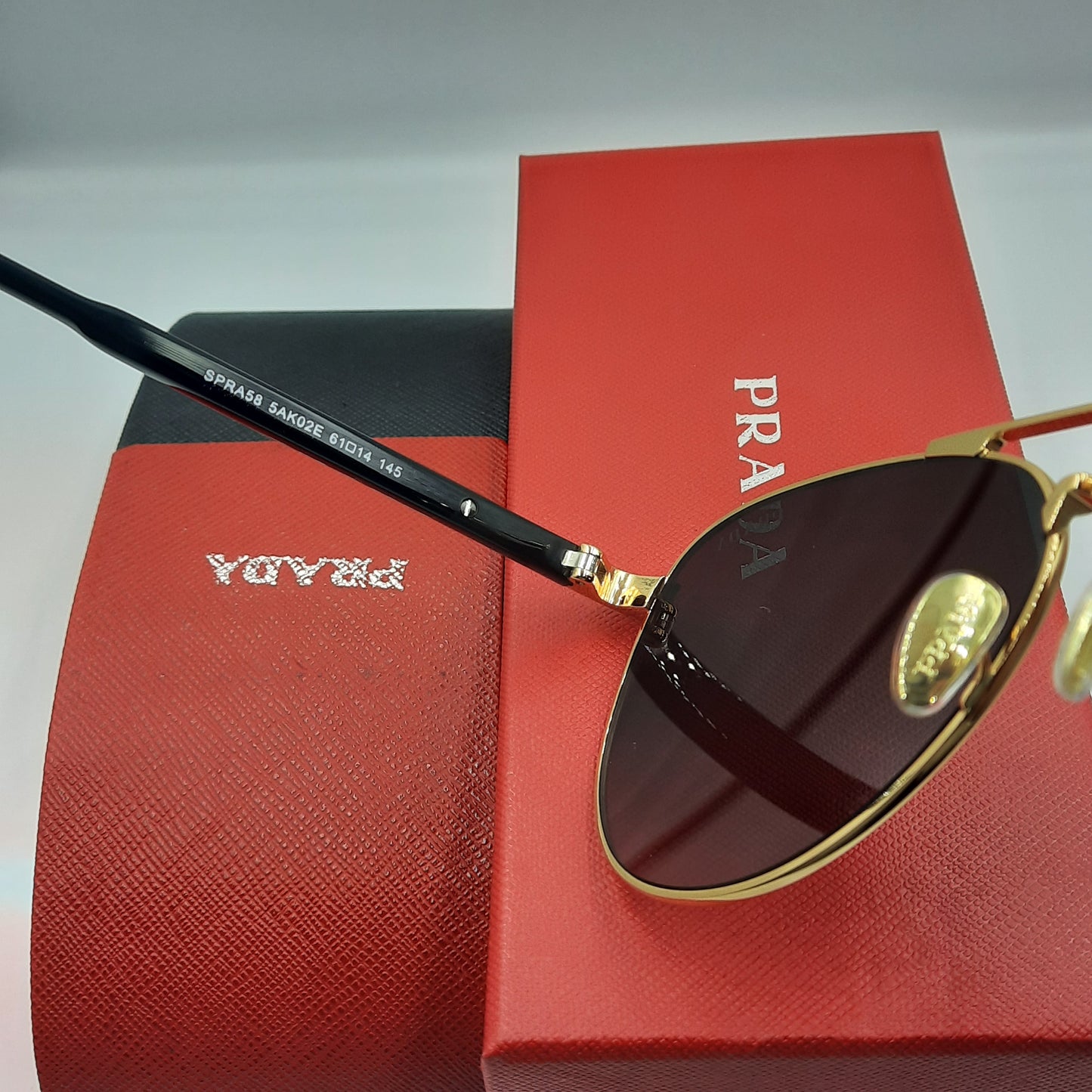 Solaires: PRADA SPRA58 rouge doré noir